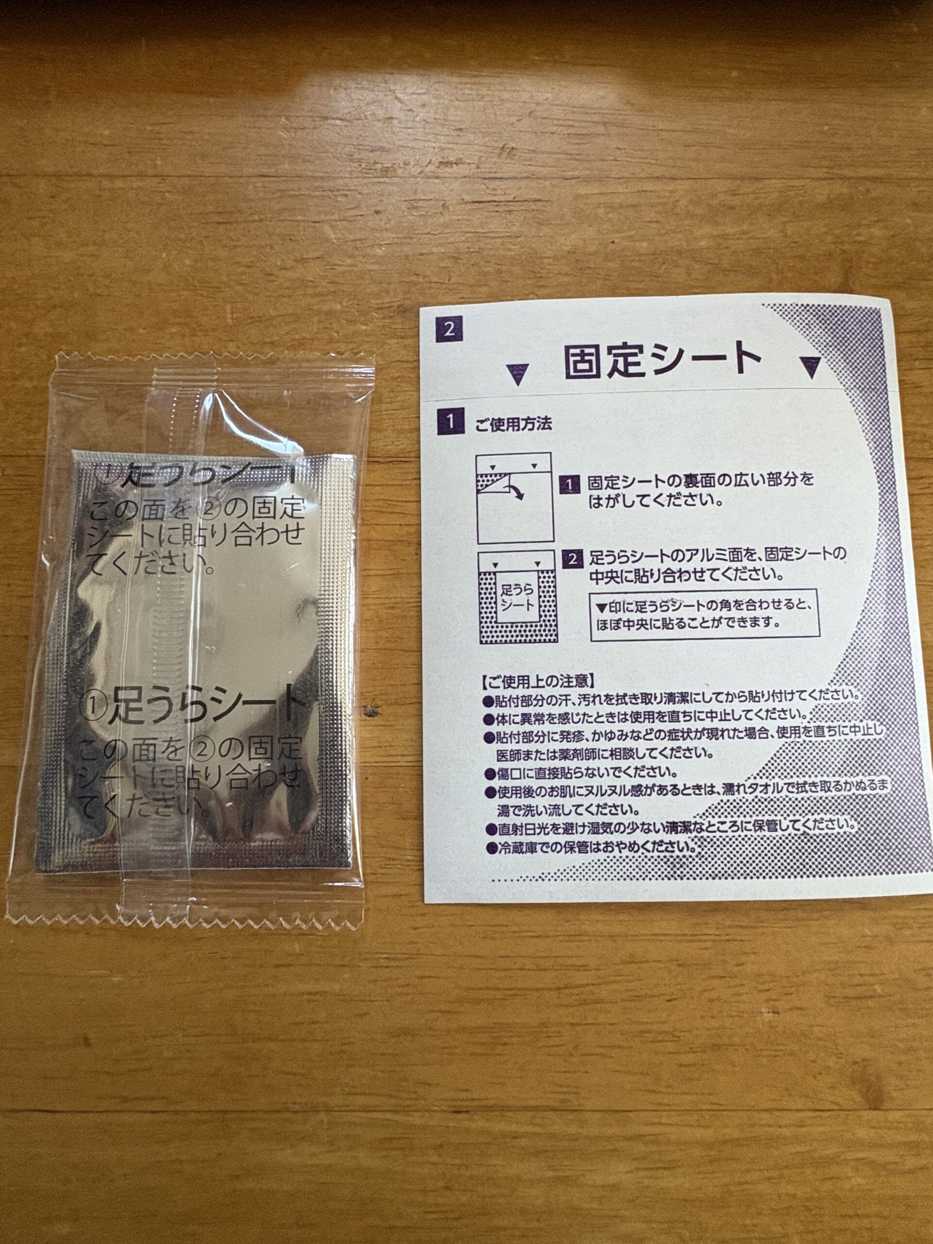 アシメグの内容物。左にアルミ面を向けた足裏シート2枚、右に使い方と注意書きが印刷された固定シート